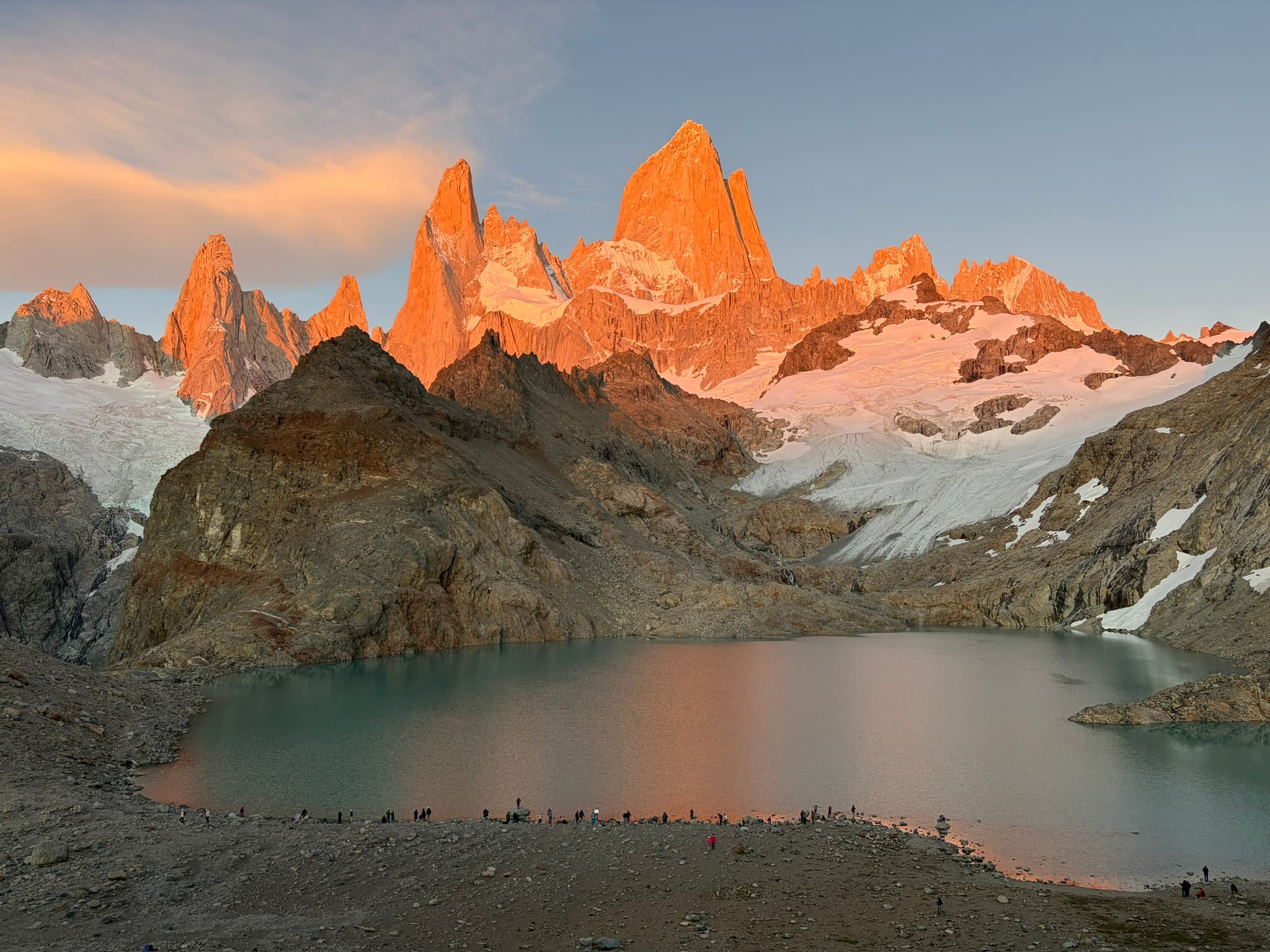 Fitz Roy massif lit orange at sunrise above a glacial lake