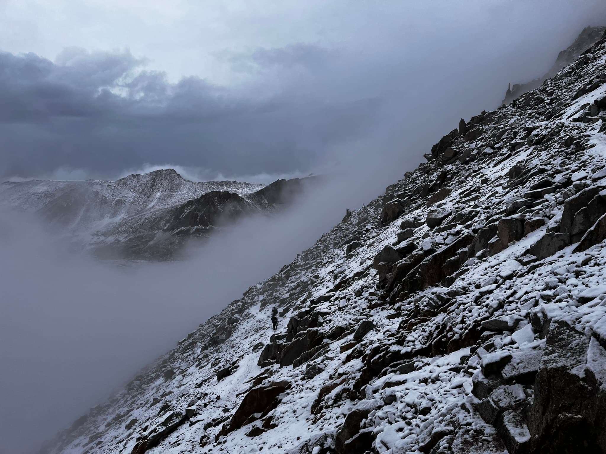 Cloud spilling over a snow-dusted ridgeline