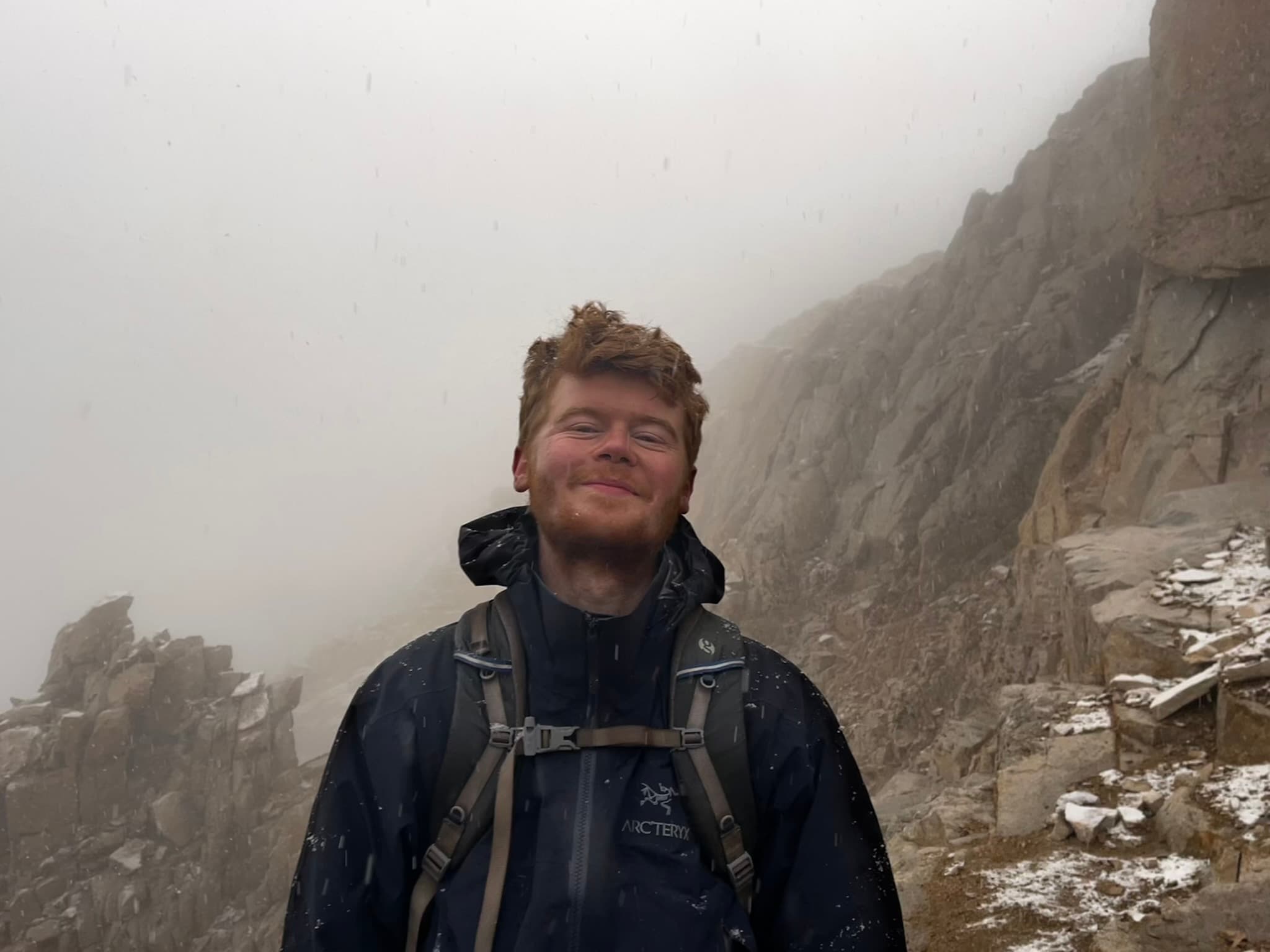 Close portrait in falling snow on an exposed rocky ridge